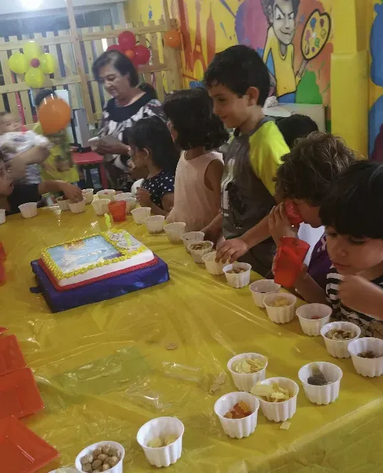 Table d'anniversaire avec gâteau et enfants attablés