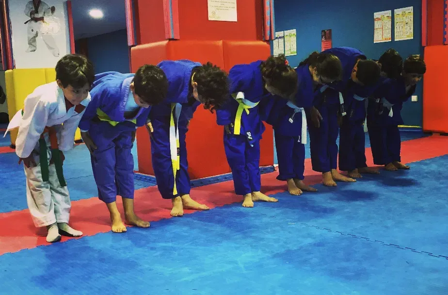 Enfants en kimono qui saluent pendant un cours de judo